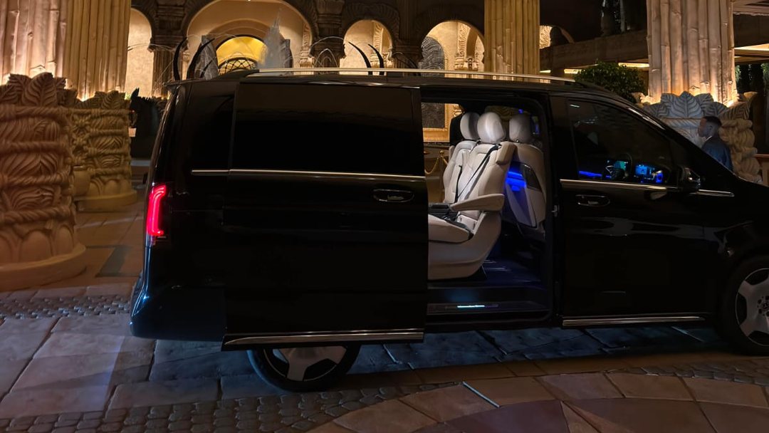 A Foreverlit Mercedes-Benz V-Class waiting with its door open under the arches of the Palace at Sun City